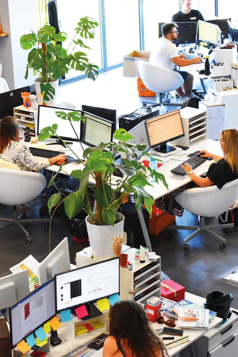 A vibrant modern office with employees collaborating at their desks.
